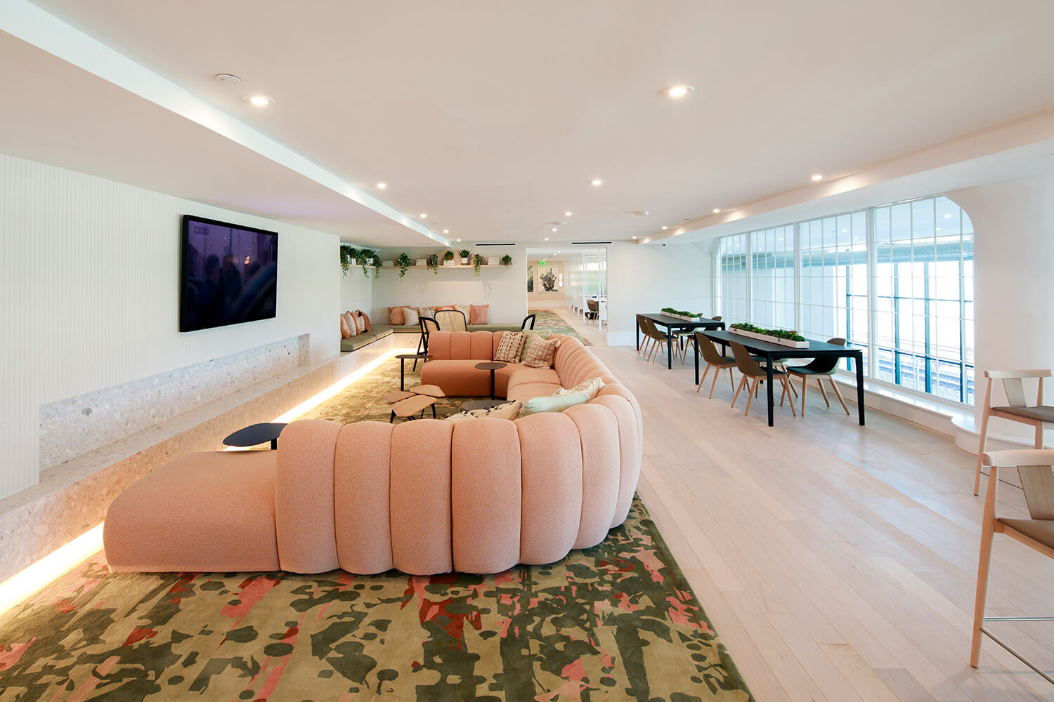 Lounge area with large plush u-shaped couch and a large television