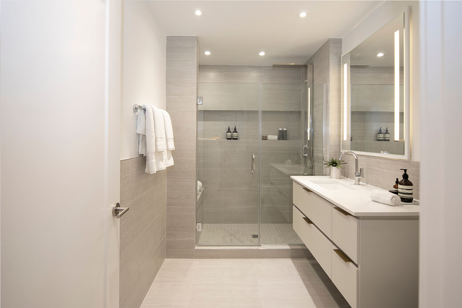 Bathroom with large vanity and a shower with a built-in seat