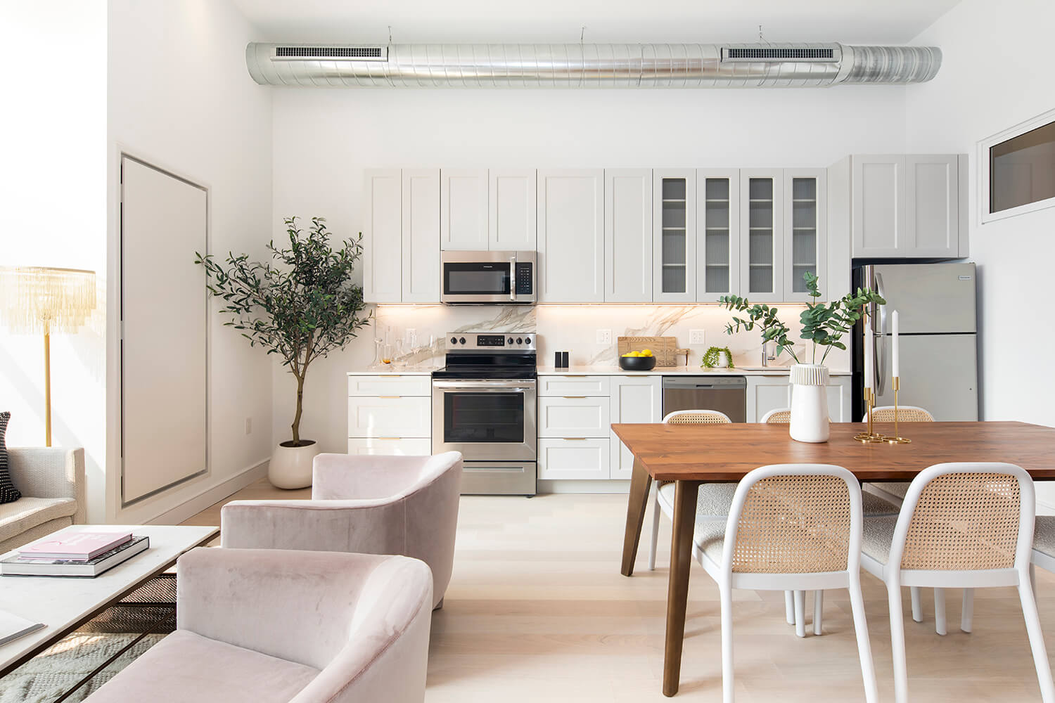 Dining Area and modern kitchen with stainless steel appliances and gold accents