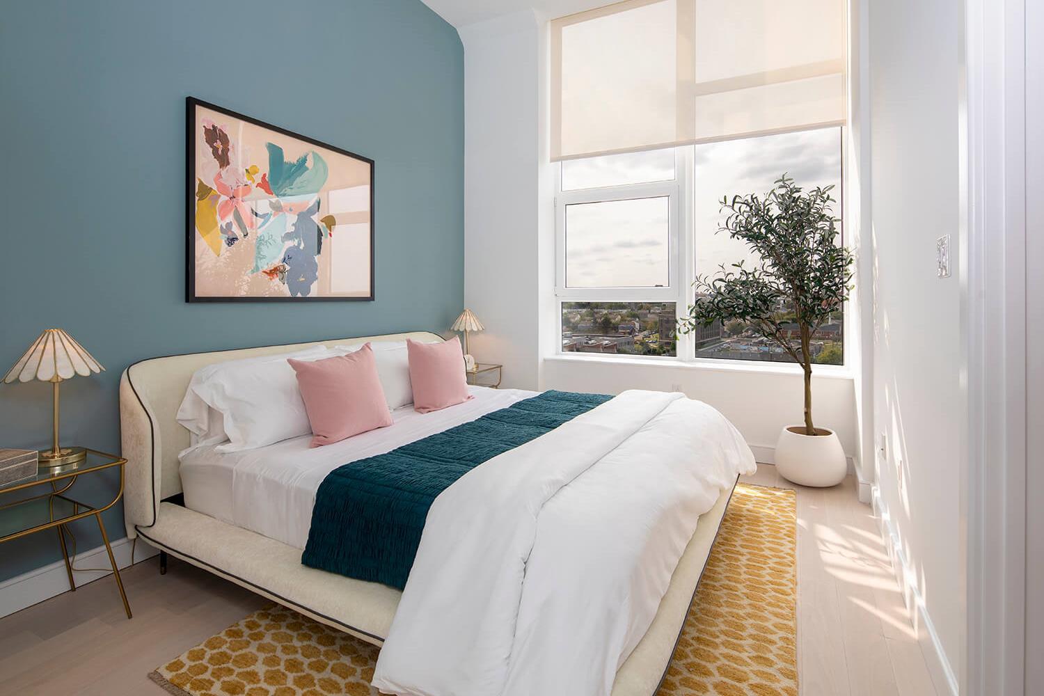 Bedroom with a rug, modern art, and lots of natural light