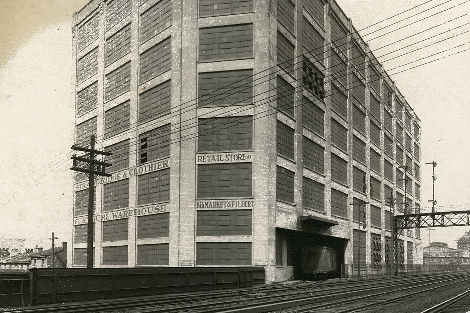 Historic black and white photo of Strawbridge and Clothier warehouse near railroad tracks