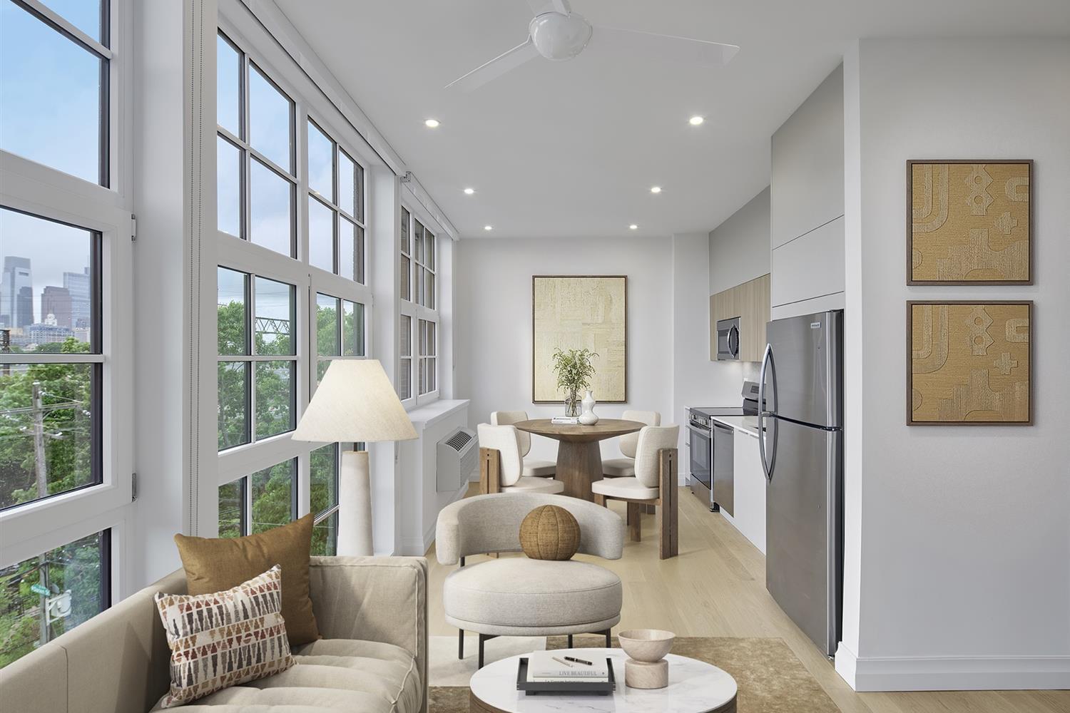 Living and kitchen area by a wall of windows